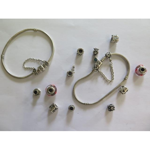 519 - Two Pandora silver bracelets and eleven charms, all generally good