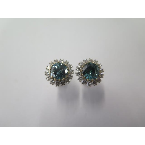 522 - A pair of 18ct white gold diamond cluster earrings, treated blue round brilliant cut diamonds each s... 