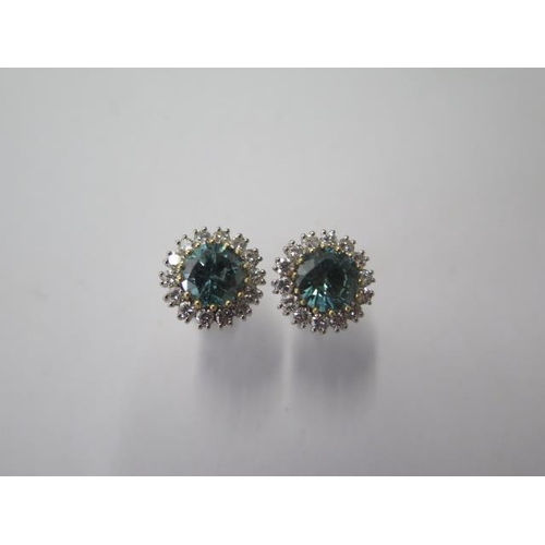 522 - A pair of 18ct white gold diamond cluster earrings, treated blue round brilliant cut diamonds each s... 