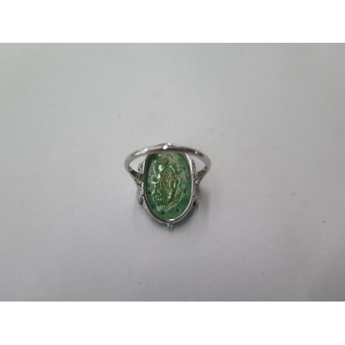 524 - An 18ct platinum carved jade ring, head approx 22mm x 15mm, size N, jade has been broken and glued, ... 