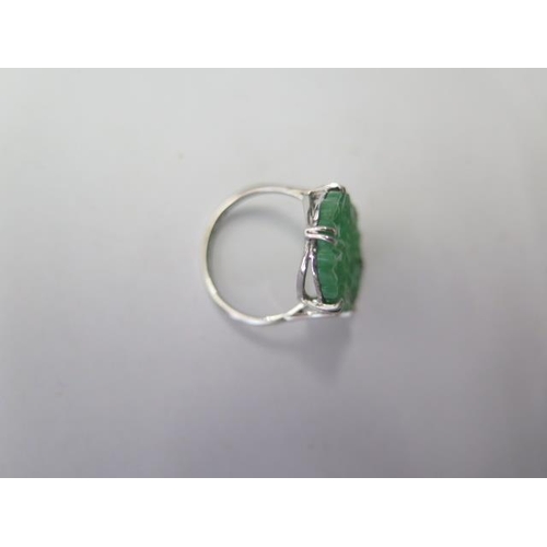 524 - An 18ct platinum carved jade ring, head approx 22mm x 15mm, size N, jade has been broken and glued, ... 