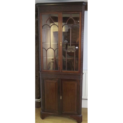 56 - An Edwardian mahogany corner cabinet with an astragel glazed top over a 2 door base with blind fretw... 