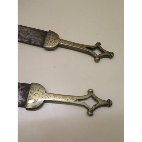 764 - A pair of brass arm daggers with scabbards, blade length 35cm