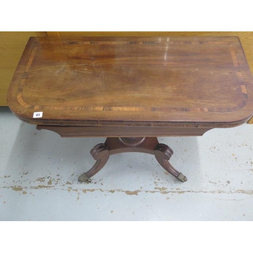 83 - A Regency crossbanded mahogany fold over tea table on a quatrefoil scroll base, 73cm tall