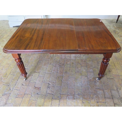 24 - A 19th century mahogany dining table with a single leaf on reeded legs, in good condition, with its ... 
