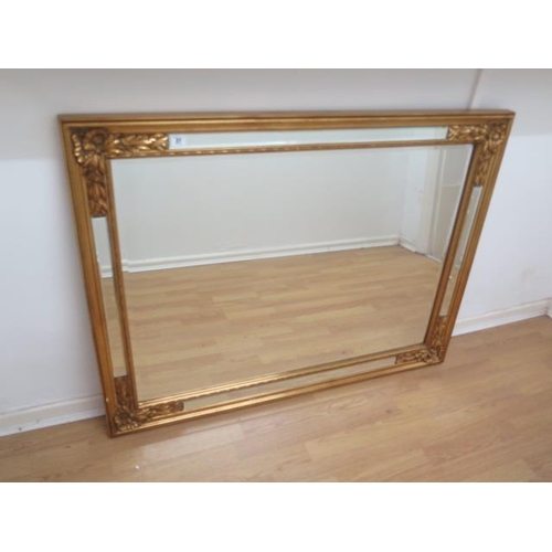 27 - A decorative gilt cushion wall mirror, 93cm x 121cm