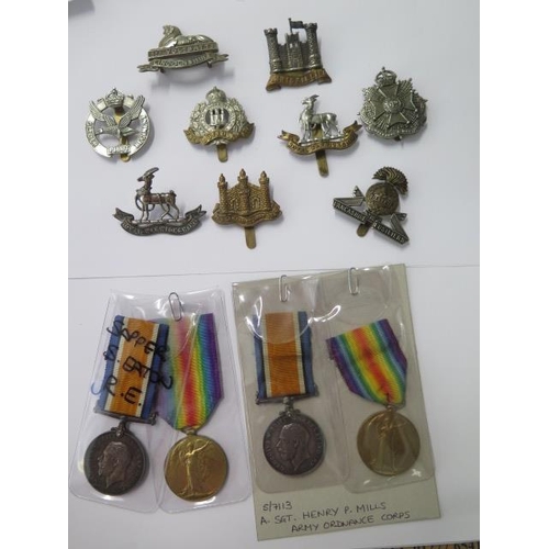 812 - Two pairs of WWI named medals and assorted cap badges