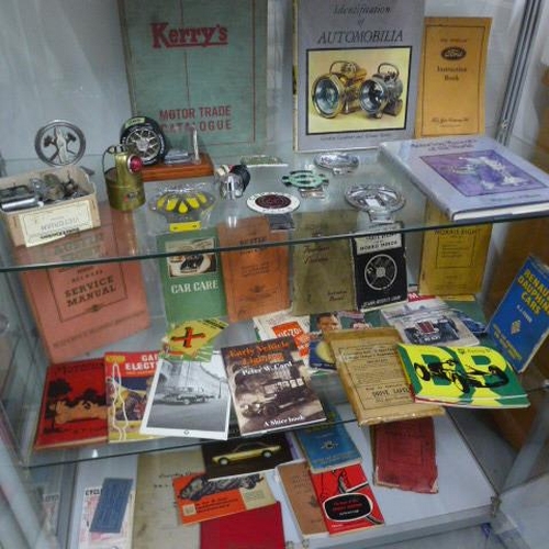 265 - Automobilia - A collection of car badges, assorted car related books and instruction booklets includ... 