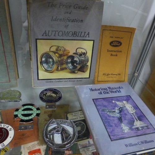 265 - Automobilia - A collection of car badges, assorted car related books and instruction booklets includ... 