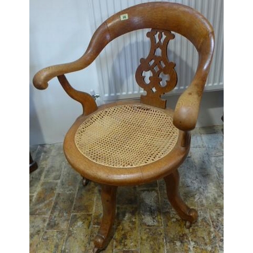 66 - A Victorian oak swivel office chair with caned seat