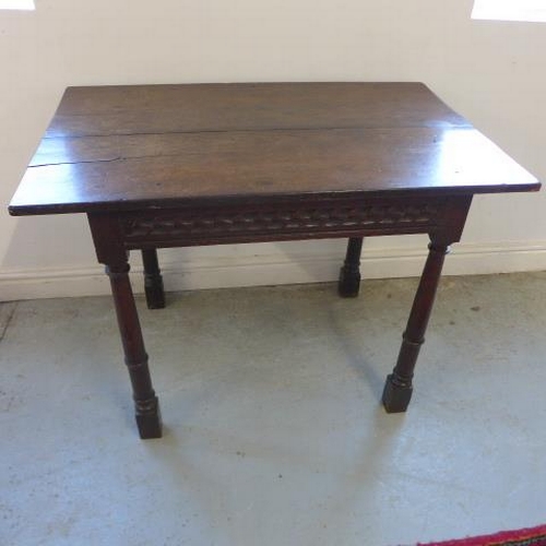 76 - An antique and later oak side table with a carved frieze - Height 71cm x 97cm x 62cm