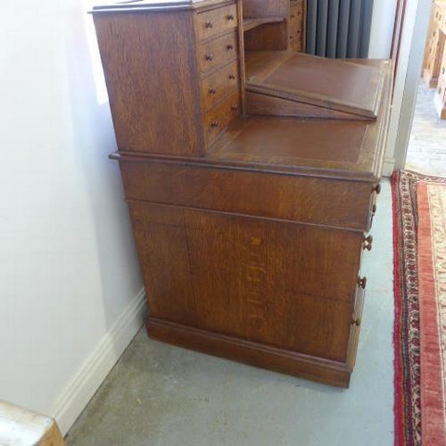 80 - A Victorian oak twin pedestal Dickens desk, the top having eight small drawers with a writing slope ... 