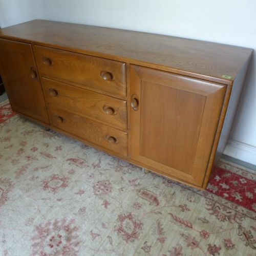 91 - An Ercol elm sideboard with three drawers and two cupboard doors on casters - Height 69cm x 155cm x ... 