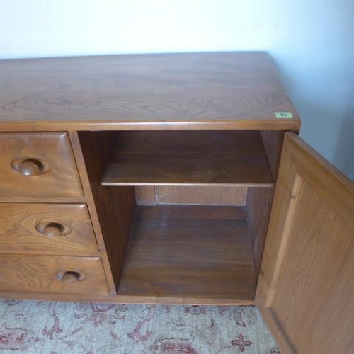 91 - An Ercol elm sideboard with three drawers and two cupboard doors on casters - Height 69cm x 155cm x ... 