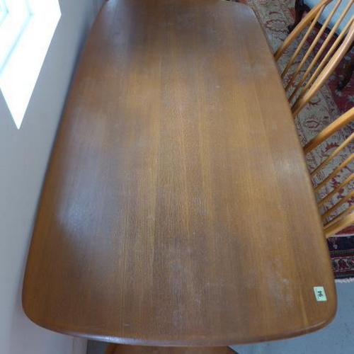 94 - An Ercol blond elm kitchen dining table with six stick back chairs including two carvers - Table hei... 