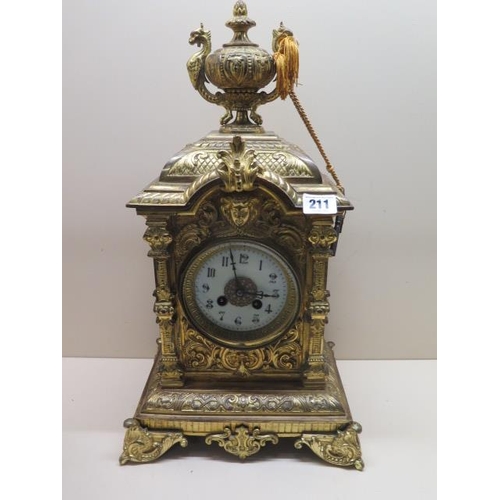 211 - A heavy brass ormolu striking mantle clock - Height 48cm - with a key and pendulum - appears overwou... 