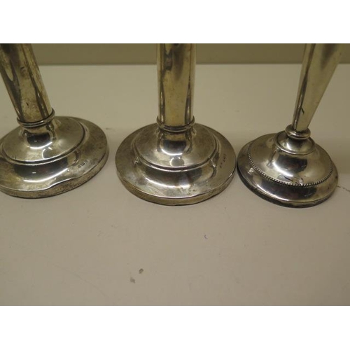 507 - Three weighted silver candlesticks - Tallest 14cm - and a silver back mirror