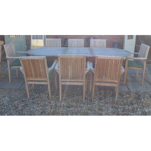 1 - A hardwood oval extending garden table and eight armchairs with seat pads - Table 75cm tall x 100cm ... 