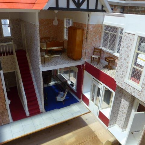 215 - A large dolls house with six rooms, a garage and  a boutique with furnishings on a caster base - Hei... 