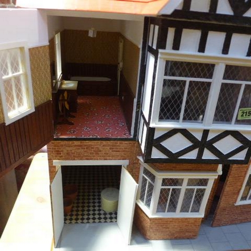 215 - A large dolls house with six rooms, a garage and  a boutique with furnishings on a caster base - Hei... 