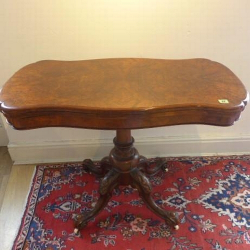 22 - A good Victorian burr walnut fold over card table with a shaped top on a carved quatrefoil base - He... 