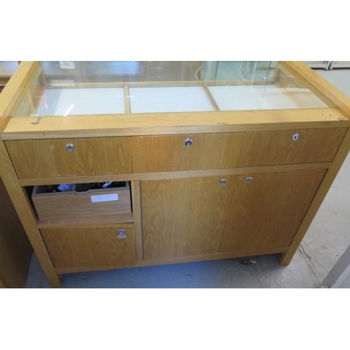 18 - A good quality jewellers shop cabinet with three sliding display drawers and three cupboard doors to... 