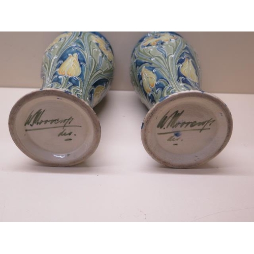 203 - William Moorcroft green signature near pair of Florian type vases - Height 25cm - one has a chip to ... 