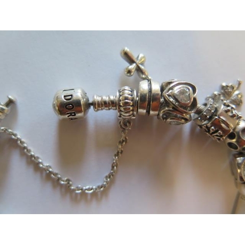 442 - A Pandora silver bracelet with assorted charms including 925 charm company and others - total weight... 