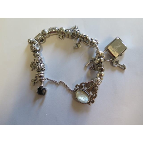 442 - A Pandora silver bracelet with assorted charms including 925 charm company and others - total weight... 