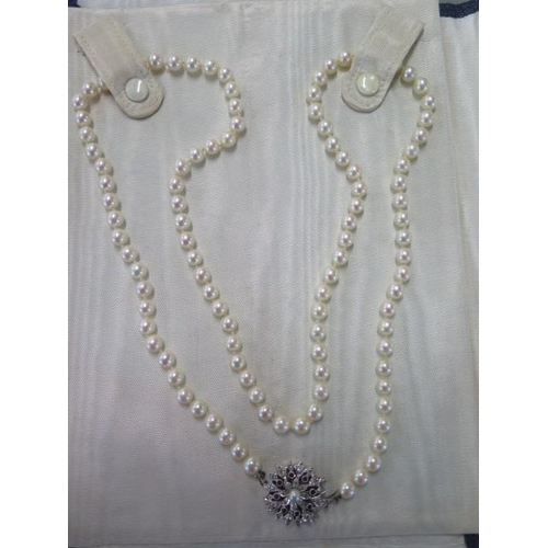 472 - A pearl necklace approx 74cm long with a diamond and ruby clasp - clasp approx 21mm diameter - pearl... 