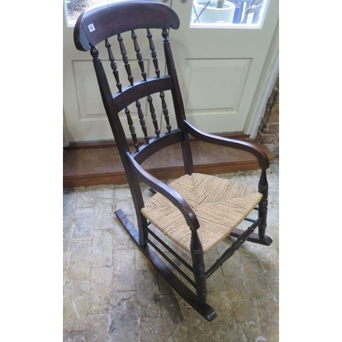 53 - An early 19th century rush seated and spindle back rocking chair - Height 112cm