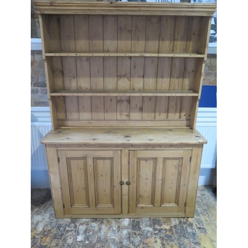 69 - A Victorian stripped pine kitchen dresser with an open rack top above a two door base - Height 211cm... 