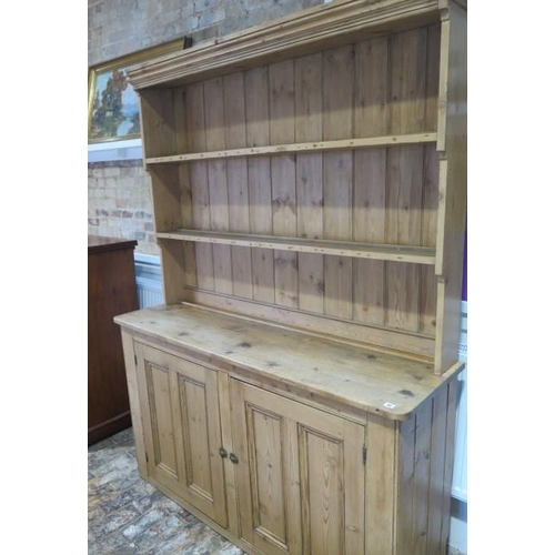 69 - A Victorian stripped pine kitchen dresser with an open rack top above a two door base - Height 211cm... 