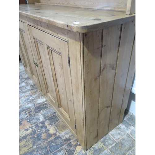 69 - A Victorian stripped pine kitchen dresser with an open rack top above a two door base - Height 211cm... 