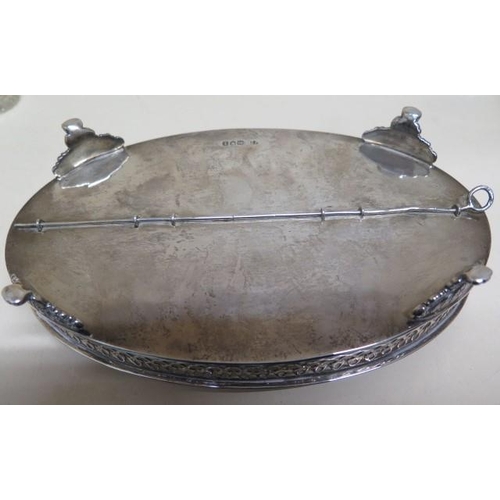152 - A good early 20th century oval silver desk stand with a pair of cut glass inkwells and a taper stick... 