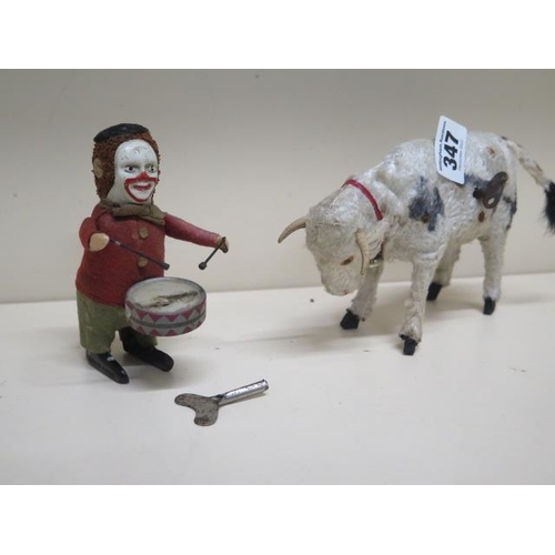 347 - A Schuco monkey playing drums together with a cow with moving head and tail