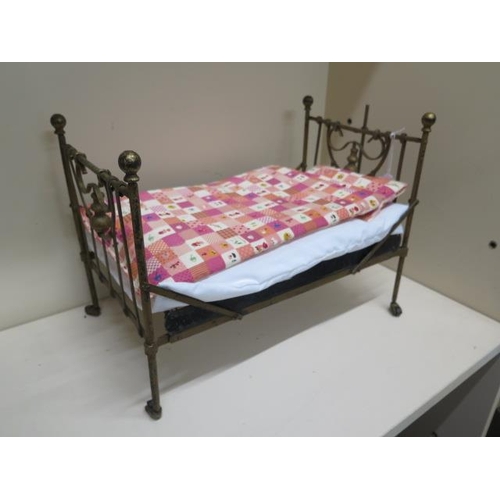 349 - A cast iron dolls bed with castor wheels