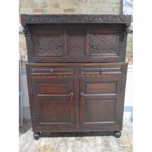 533 - An 18th century oak court cupboard with a carved two door top over two panel front drawers and two c... 