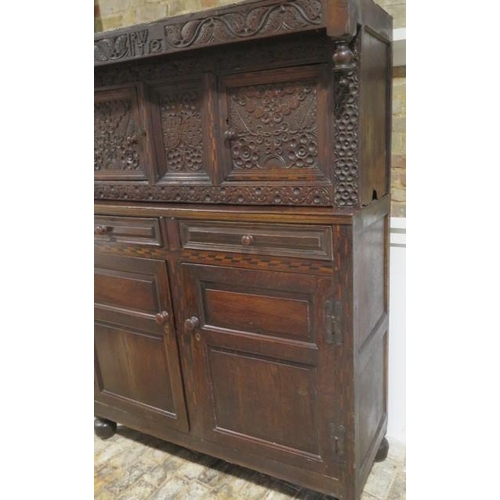 533 - An 18th century oak court cupboard with a carved two door top over two panel front drawers and two c... 