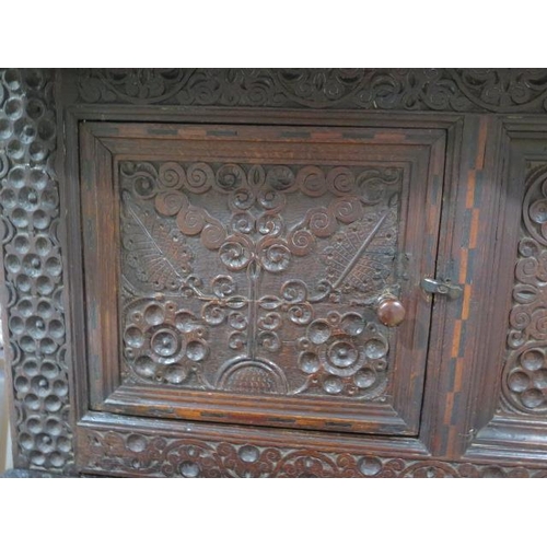 533 - An 18th century oak court cupboard with a carved two door top over two panel front drawers and two c... 