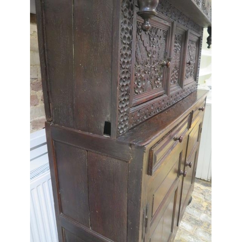 533 - An 18th century oak court cupboard with a carved two door top over two panel front drawers and two c... 