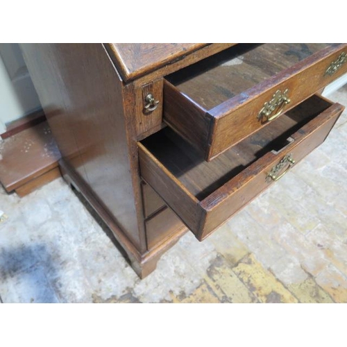 564 - A Georgian oak bureau with a well and fitted interior above two short and three long drawers on brac... 