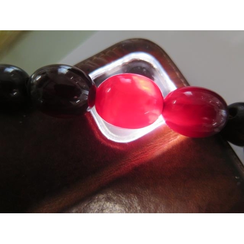 59 - A string of cherry amber type beads - Length 78cm x 22cm x 17mm largest - approx weigh 88 grams