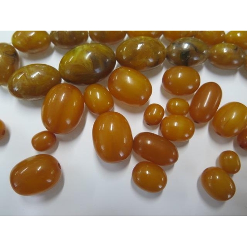 60 - Two strings of Butterscotch amber type beads - one broken, largest bead 25mm x 19mm - weight approx ... 