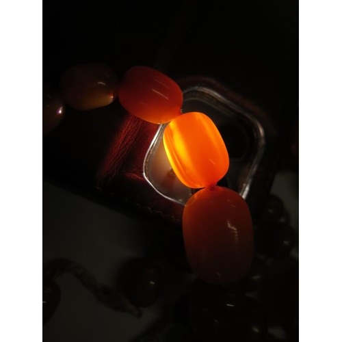 60 - Two strings of Butterscotch amber type beads - one broken, largest bead 25mm x 19mm - weight approx ... 