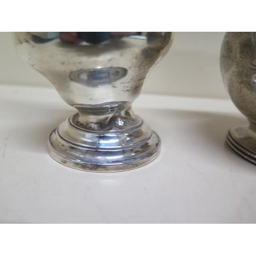135 - A silver caster and a silver jug - engraved - both with some denting, approx weight 12 troy oz
