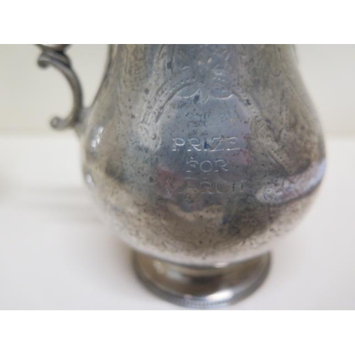 135 - A silver caster and a silver jug - engraved - both with some denting, approx weight 12 troy oz