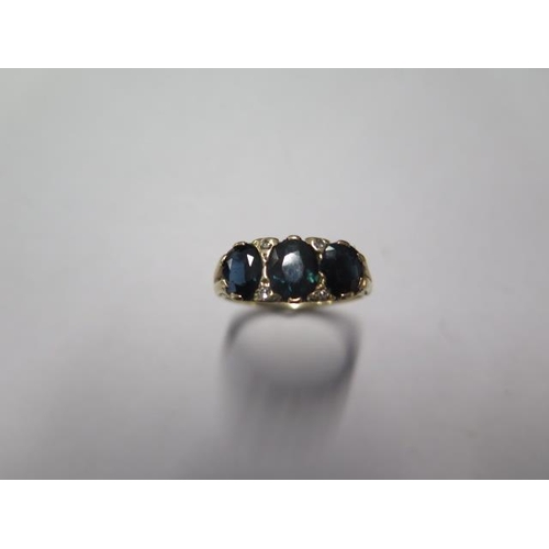 27 - A yellow gold three stone sapphire ring - tests to 9ct gold - ring size Q - approx weight 4.2 grams ... 