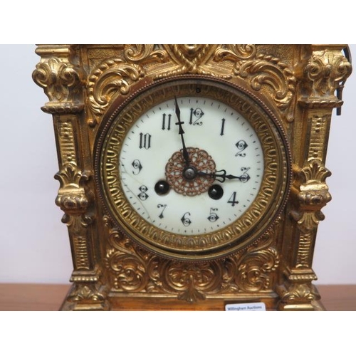 446 - A heavy brass ormolu striking mantle clock, 48cm tall, with a key and pendulum, appears overwound