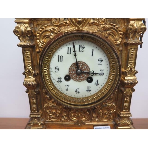 412 - A heavy brass ormolu striking mantle clock, 48cm tall, with a key and pendulum, appears overwound